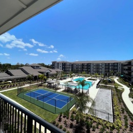 Access to resident-only features  view from a balcony of a pickleball court and a pool in a courtyard