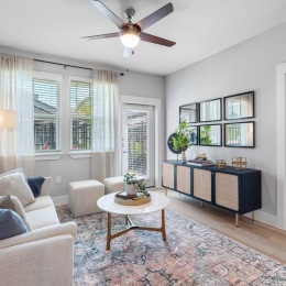 Spacious and well-lit living spaces living room with fan couch and coffee table