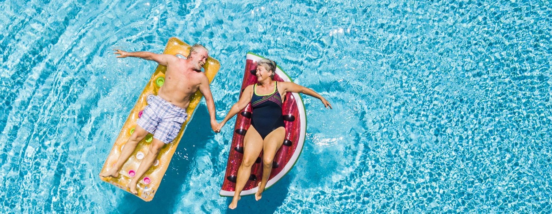 a couple of people floating in a pool