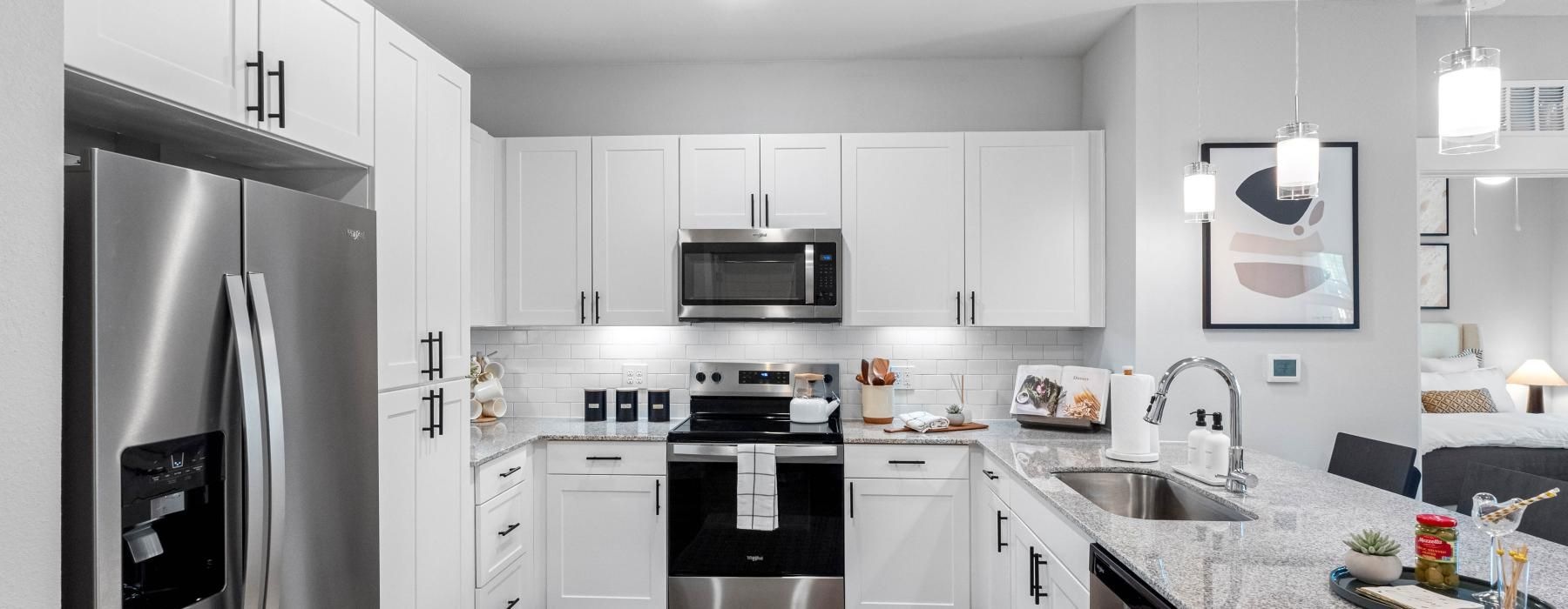 a kitchen with white cabinets and stainless steel appliances