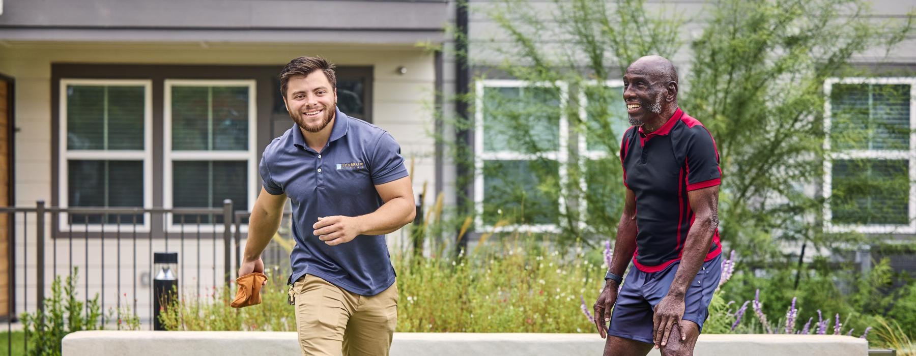 a couple of men playing corn hole